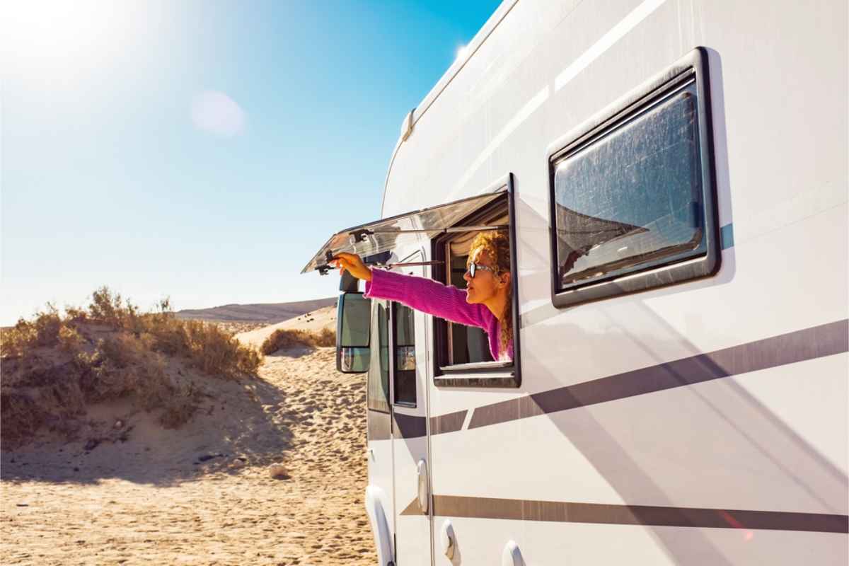 woman sticking her head out of her motorhome window on a sunny day